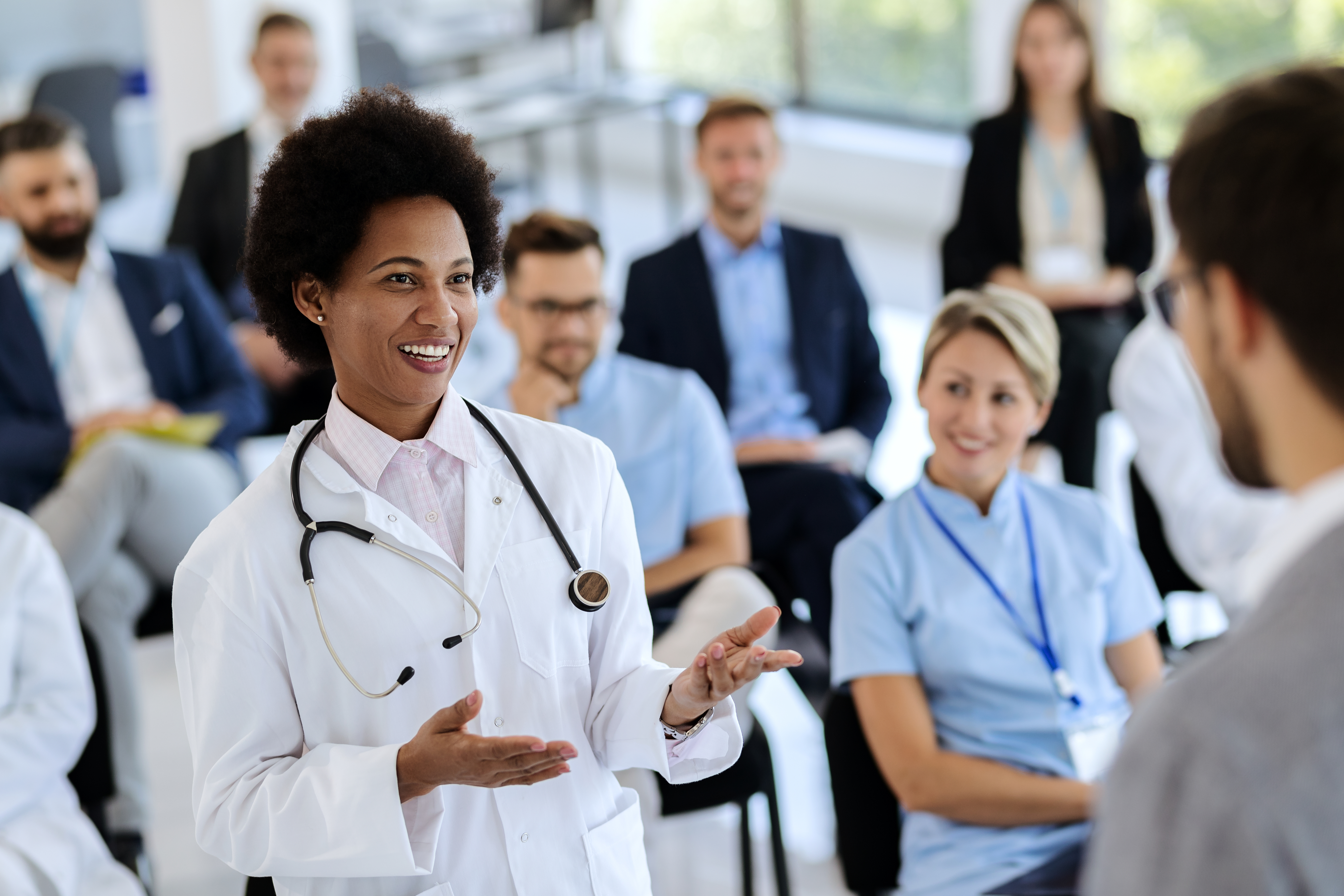 A doctor discusses a concept with a presenter at a conference