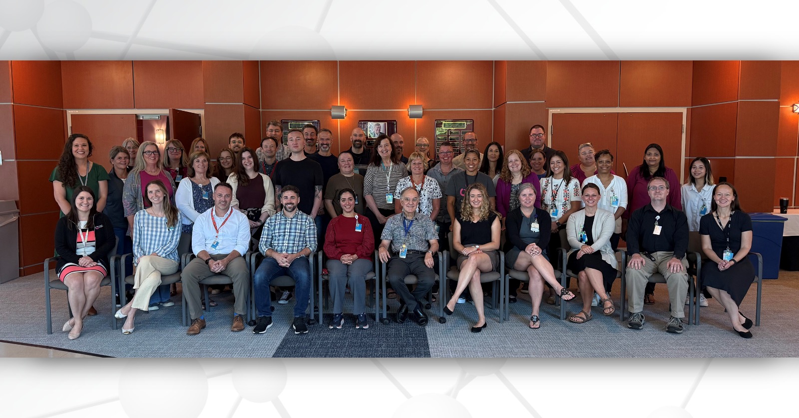 Group photo of approximately 50 DMCC members seated and standing in rows.