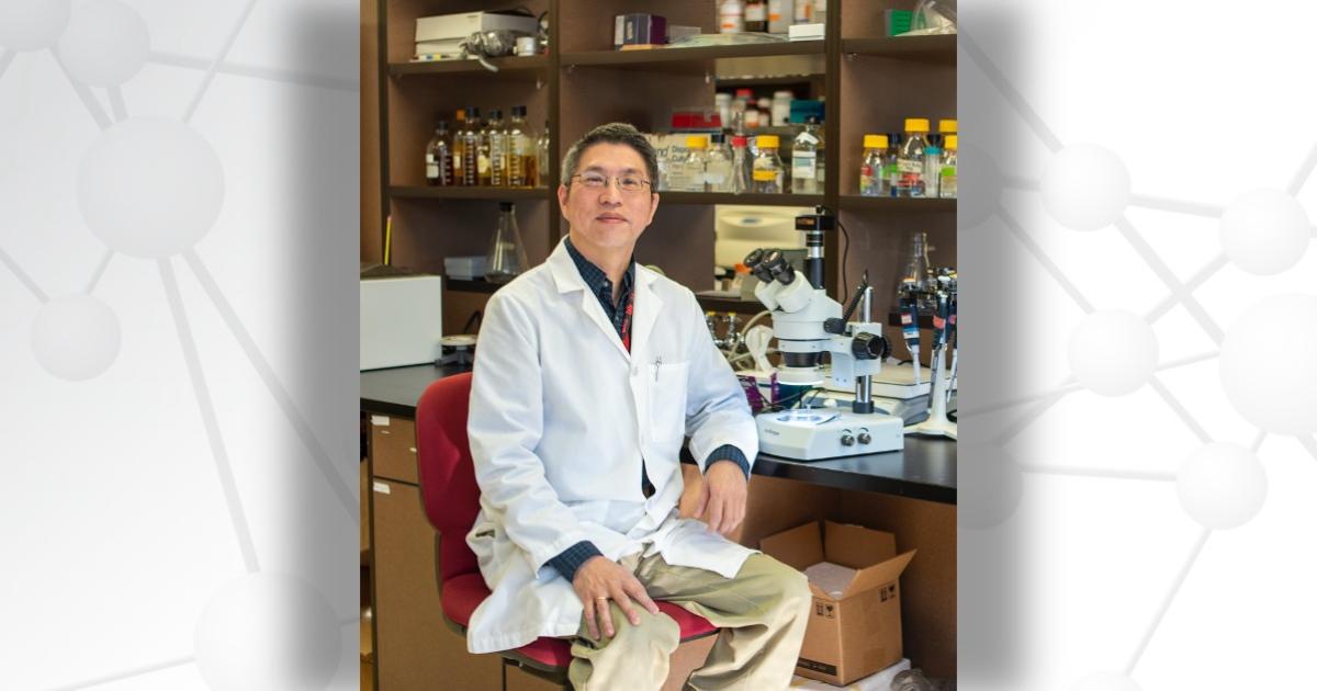 Kent Lai, PhD, sitting in a chair in his lab